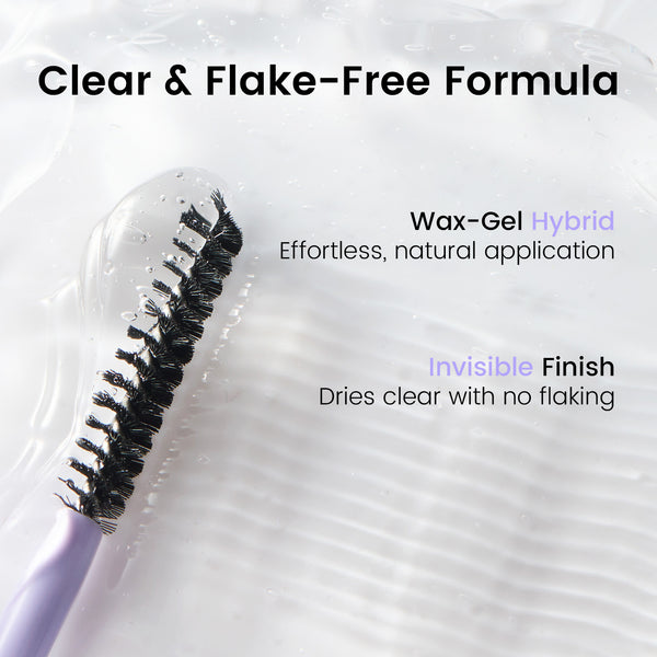A close-up of a cosmetic brush with black bristles and a pale lavender handle, shown on a glossy white textured surface with marketing text reading 'Clear & Flake-Free Formula' and 'Wax-Gel Hybrid Effortless, natural application.'.